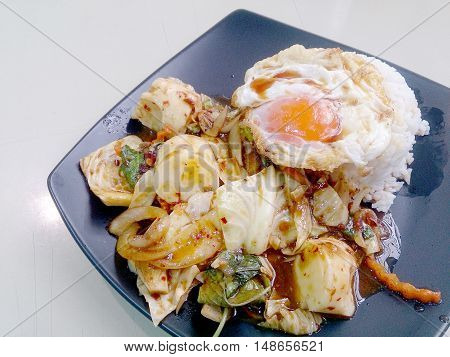 Stir Fried Mixed Vegetables With Roasted Chili Paste , Fried Egg & Thai Jasmine Rice On Black Dish.