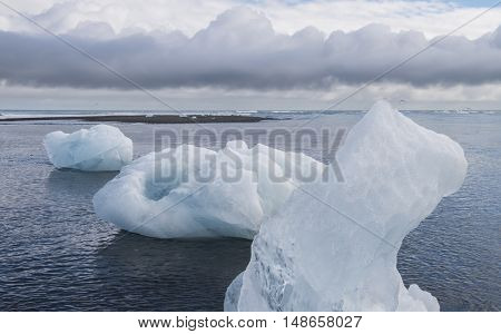 Three Ice blocks on beach and Artic Terns near river Jokulsa at Jokulsarlon glacier lagoon in the Vatnajokull National Park Iceland.