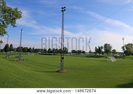 A view of a net on a vacant soccer pitch in morning light.