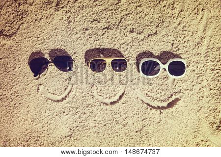 Top view of sandy beach with smiling family faces and sunglasses