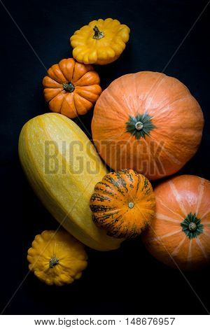 Halloween pumpkins on black background. Top view, vertical.