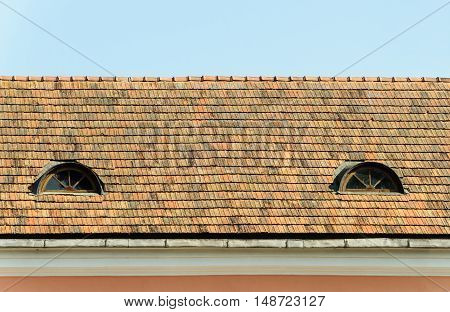 Old tiled roof with two attic windows in the Trinity suburb old part of Minsk Belarus