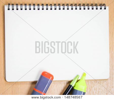 office table desk with color pen. blank paper of book is use for putting some texts or images.