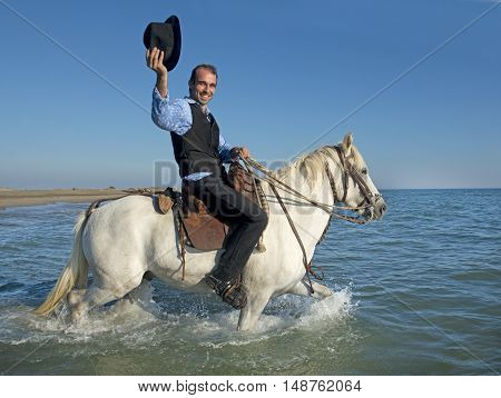 herdsman and Camargue walking in the sea