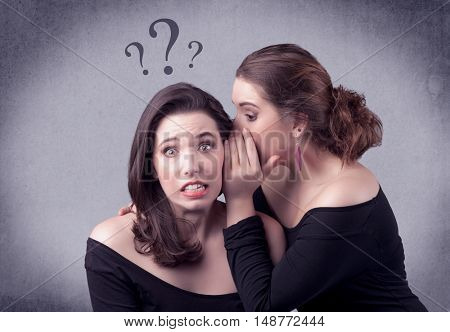 A teenager girl looking confused with drawn question marks above the head, while a girlfriend whispers something in her ear concept.