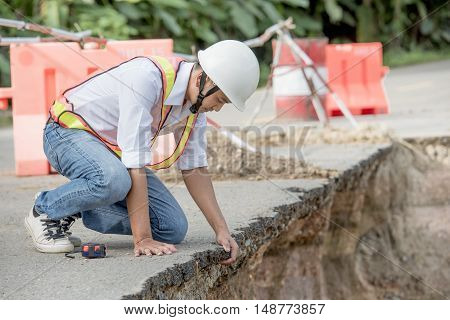 Engineer checking damaged road asphalt concrete design