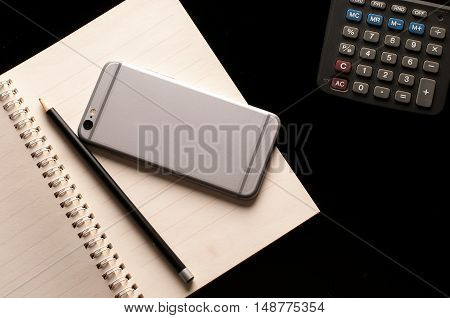 Stationary, Notebook, smartphone, pencil and calculator use in business office black background