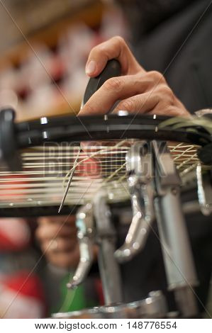 Tennis Stringer Holding Awl And Doing Racket Stringing