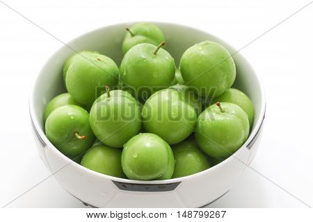 Bowl of fresh and green plums. Spring fruits. Food.