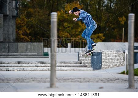 Boy doing skateboard trick smithgrind on ledge