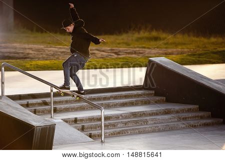 Boy doing skateboard trick tailslide in skatepark