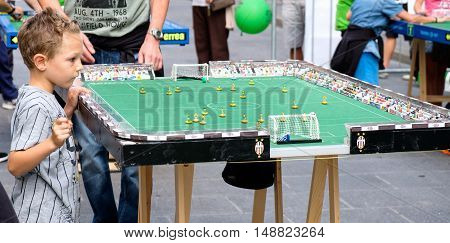 Bologna Italy 18 September 2016: A child focusing on a Subbuteo game