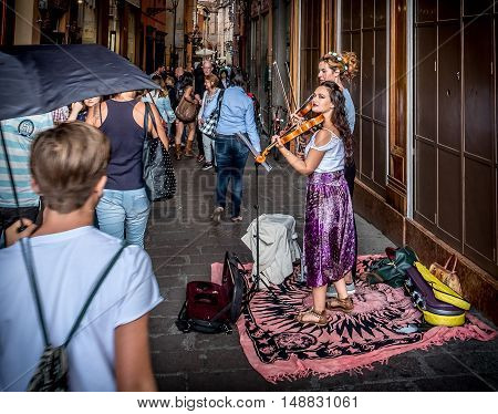 Bologna Italy 18 September 2016: two buskers violinists perform for the passersby in the historic district of Bologna.