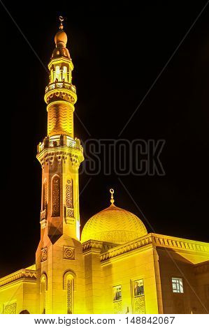 The Minaret and dome of Jumeirah Mosque illuminated at night in Jumeirah Beach, Dubai, UAE. The Jumeirah Mosque is one of the symbols of Dubai and is the only religious monument open to non-Muslims.