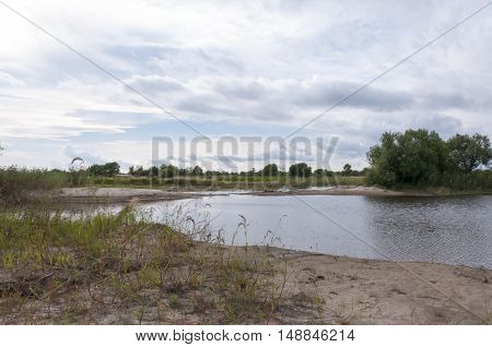 Wild sandy river beach in cloudy weather