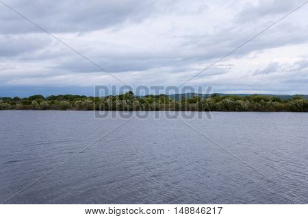 Summer landscape by the river with clouds