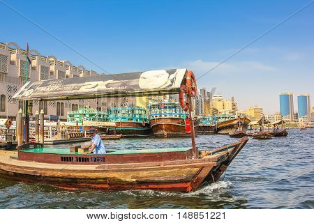 Dubai, United Arab Emirates - May 3, 2013: close up of traditional wooden boat docked on the Bay Creek in United Arab Emirates. On background, skyline of Deira, the old downtown of Dubai.