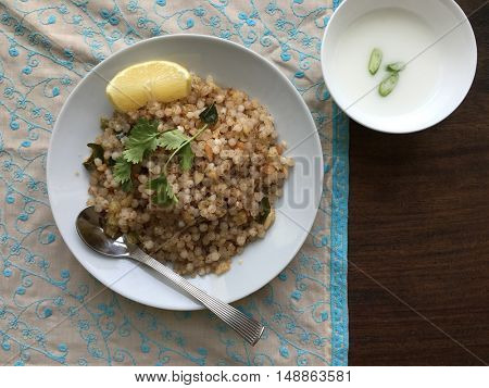 Sabudana khichadi: an authentic maharastrian food and recipe. A plate full of khichadi with lime wages and buttermilk as side dish.