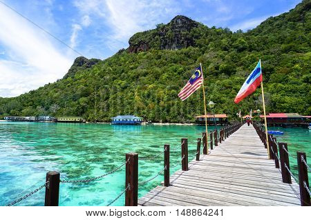Semporna,Sabah-Sep 10,2016:Wooden jetty with Sabah & Malaysia flag at Bohey Dulang tropical island,Semporna,Sabah.Bohey Dulang Island is one of the most popular islands in Tun Sakaran Marine Park.