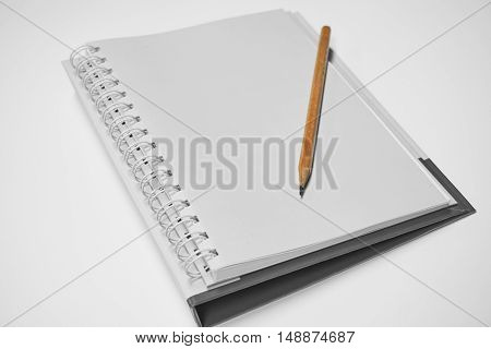 Wooden pencil put on a notebook. Selective focus on pencil which is put on the notebook in black and white background