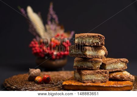 Fresh Dutch filled spicy cookies with almonds on autumn colored and dark background