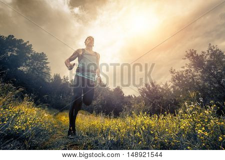 Trail running athlete moving through the meadow