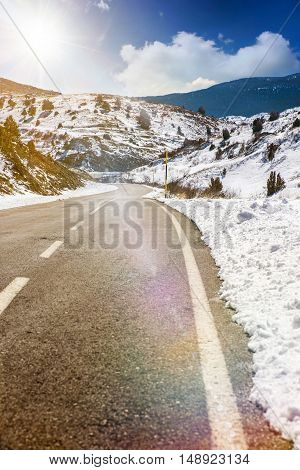 Snowy mountain country road in winter sunny day