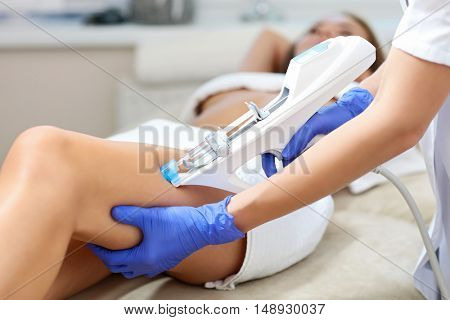 Picture of woman having leg mesotherapy in beauty salon