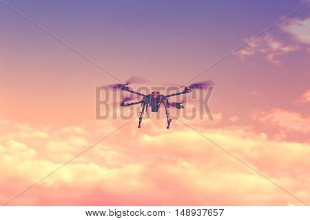 Silhouette Of Drone Hovering In A Colorful Sunset. Toned Image. Soft Focus