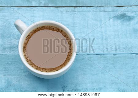 hot coffee in a white Coffee cup on blue wooden table at coffee shop.