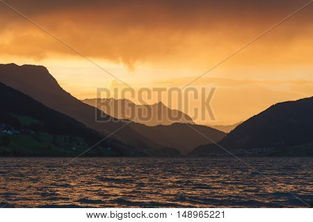 Beautiful view of the lake Resia. Dramatic sky and colorful sunset. Alps, Italy, Europe.