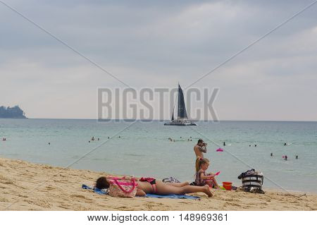 Phuket Island, Thailand - APRIL 08, 2016: family enjoy sunbathe on white sand beach on Phuket island in Thailand