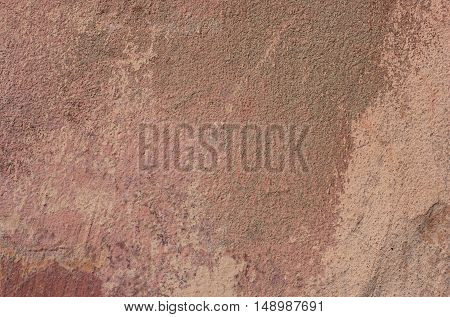 Shabby red paint on a concrete walll.ragged old surface.