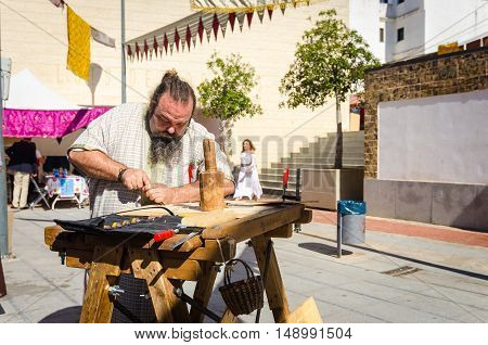 Badajoz Spain - September 23 2016: Medieval craftsman making arrows in market during celebration Almossassa in Badajoz Extremadura Spain