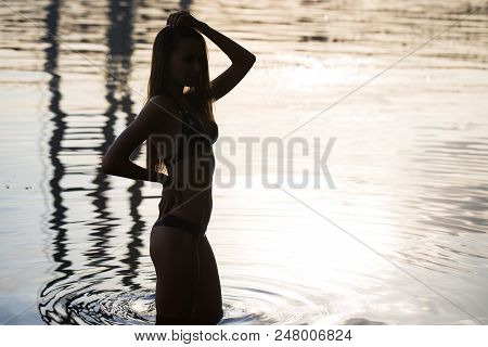 Side View Of Back Light Of A Woman Silhouette Breathing Deep Fresh Air At Warm Sunrise In Front Of S