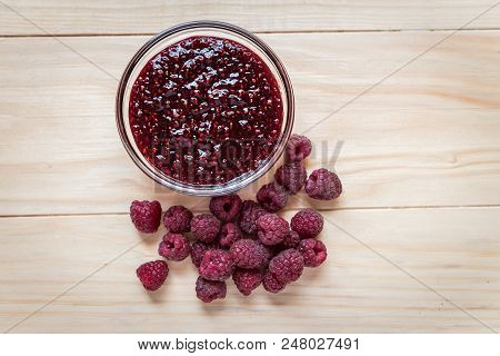 Homemade Raspberry Jam In A Glass Bowl With Fresh Ripe Organic Raspberries On A Wooden Table