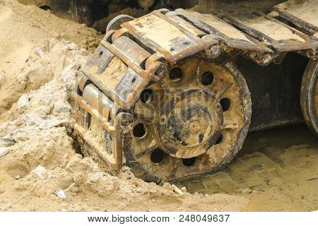 Old Iron Caterpillar In Wet Sand. Rusty Steel Wheels And Caterpillar Tape Of A Large  Bulldozer, Tan