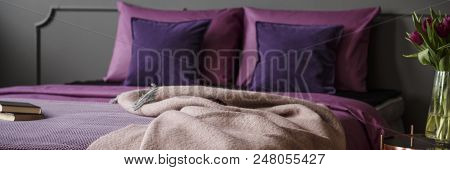 Blanket Thrown On King-size Bed With Purple Bedding Standing In Dark Grey Bedroom Interior With Fres