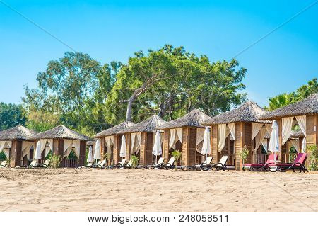 Antalya, Turkey - 9 May 2018: Wooden Beach Pavilions On The Shore Of A Sandy Beach - The Mediterrane