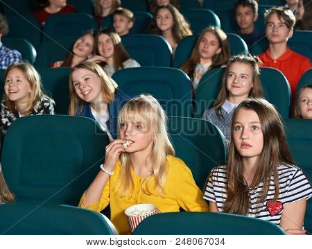 Beautiful Girls Looking At Screen With Steadfast Eyes And Watching Interesting Movie. Cute Blonde Ea
