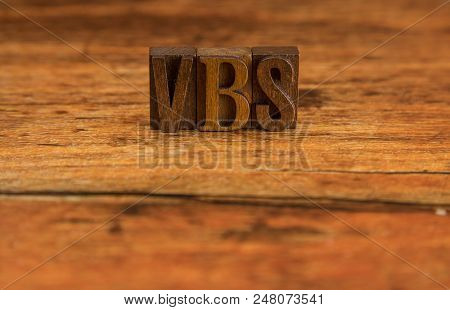 Vbs For Vacation Bible School Spelled In Block Letters On A Wooden Table