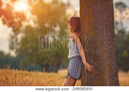 Cute Smiley Girl Embracing The Oak Tree In Nature.