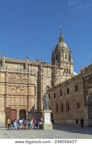 Salamanca, Spain, July 2018: Tourists Observing The Plateresque Facade Of The Historic Building Of T