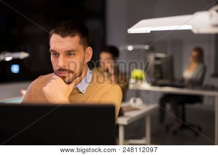 business, deadline and technology concept - man with computer working at night office
