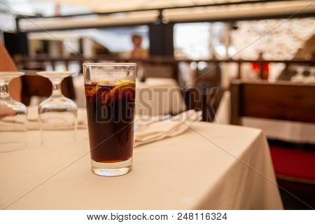 Glass Of Cold Drink With Lemon In Street Cafe.