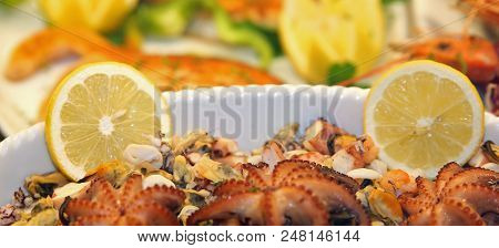 Plate Of Fresh Fish Topped With Two Slices Of Lemon Served In A Luxury Restaurant