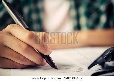 Close Up Of Woman Hands Writing Inon Paper Placed On Wooden In Office