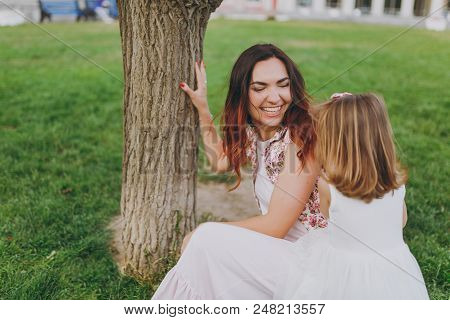 Joyful Woman In Light Dress Play And Have Fun With Little Cute Child Baby Girl On Green Grass Lawn I