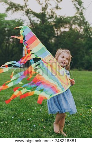 Pretty Little Cute Child Baby Girl In Denim Dress Walking, Play With Colorful Kite And Have Fun In G