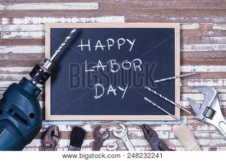 Chalk Board With Text Happy Labor Day With Variety Gruge Rusty Handy Tools On A Rusty Wooden Table.